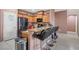 This open kitchen boasts granite counters, wood cabinetry, tile floors, and a black stainless steel refrigerator at 9457 Alma Ridge Ave, Las Vegas, NV 89178
