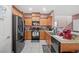 Charming kitchen featuring wood cabinets, granite countertops, stainless steel appliances, and tiled flooring at 9457 Alma Ridge Ave, Las Vegas, NV 89178