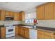 Bright kitchen features wood cabinets, white appliances, and laminate countertops at 9535 Golden Scots Ct, Las Vegas, NV 89123