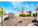 Spacious backyard with a small shed, rock landscaping, and lush plants under a bright blue sky at 988 Flapjack Dr, Henderson, NV 89014