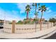 Property featuring a charming stucco wall, mature landscaping, and a palm tree-lined street at 988 Flapjack Dr, Henderson, NV 89014