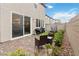 Cozy outdoor patio space with pavers, artificial turf, and dining area visible through sliding glass door at 10190 Natural Anchor St, Las Vegas, NV 89166