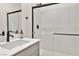 Modern bathroom featuring a glass-enclosed shower and sleek vanity with black hardware at 10190 Natural Anchor St, Las Vegas, NV 89166