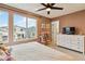 Bedroom featuring a large window, dresser, ceiling fan, and stylish furnishings at 10190 Natural Anchor St, Las Vegas, NV 89166
