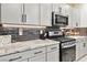 Modern kitchen with gray backsplash, stainless steel appliances, and granite countertops at 10190 Natural Anchor St, Las Vegas, NV 89166