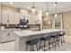 Spacious kitchen with island, seating, gray cabinets, stainless steel appliances and modern pendant lighting at 10190 Natural Anchor St, Las Vegas, NV 89166