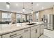 Bright kitchen with granite countertops, pendant lighting, stainless steel appliances, and view into the dining area at 10190 Natural Anchor St, Las Vegas, NV 89166