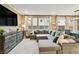Comfortable living room with a large sectional sofa, modern media console, and ample natural light at 10190 Natural Anchor St, Las Vegas, NV 89166