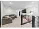 Spacious loft with a large sectional, mounted TV, and modern staircase railing at 10190 Natural Anchor St, Las Vegas, NV 89166