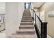 Carpeted staircase with modern railing and natural light, connecting to kitchen at 10190 Natural Anchor St, Las Vegas, NV 89166