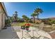 Charming backyard with patio seating and lush palm trees at 10212 Donald Weese Ct, Las Vegas, NV 89129