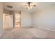 Spacious bedroom with ceiling fan and plush carpet, connecting to a bathroom at 10212 Donald Weese Ct, Las Vegas, NV 89129