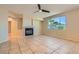 Bright living room with tile flooring, fireplace, and a view of palm trees through a large window at 10212 Donald Weese Ct, Las Vegas, NV 89129
