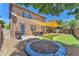 The backyard has artificial grass, trampoline, and outdoor seating beneath a sun sail for shade at 10353 Settlers Run Ave, Las Vegas, NV 89166