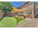 Spacious backyard featuring a shaded patio, artificial grass, trampoline, and ample seating at 10353 Settlers Run Ave, Las Vegas, NV 89166