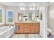 Bathroom featuring double vanity, soaking tub, and ample counter space with natural light at 10353 Settlers Run Ave, Las Vegas, NV 89166