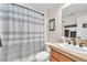Clean bathroom featuring a shower with a stylish curtain, a vanity with a sink, and modern fixtures at 10353 Settlers Run Ave, Las Vegas, NV 89166