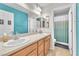 Bright bathroom featuring a double vanity, ample counter space, and a shower with a curtain at 10353 Settlers Run Ave, Las Vegas, NV 89166