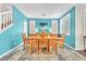 Bright dining room boasts a blue accent wall, a wooden dining table, and stylish window shutters at 10353 Settlers Run Ave, Las Vegas, NV 89166