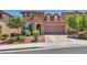 Charming two-story home featuring a stone facade, manicured landscaping, and attached two-car garage at 10353 Settlers Run Ave, Las Vegas, NV 89166