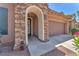 Close-up of the front entrance featuring a stone archway, and a cozy welcome sign at 10353 Settlers Run Ave, Las Vegas, NV 89166