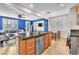 Spacious kitchen island with a stainless steel dishwasher and ample counter space, with living area at 10353 Settlers Run Ave, Las Vegas, NV 89166