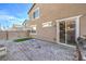 Backyard with stone patio, patch of grass, built-in grill, and access to the house at 10940 Oregano Ave, Las Vegas, NV 89166