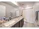 Bathroom with a large mirror, stylish counter and tile floor, and a shower/tub combo at 10940 Oregano Ave, Las Vegas, NV 89166