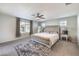 Bright bedroom with a neutral color palette, ceiling fan, and large windows offering natural light at 10940 Oregano Ave, Las Vegas, NV 89166