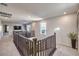 Hallway features carpet, a railing, natural light and leads into the living area with television at 10940 Oregano Ave, Las Vegas, NV 89166