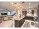 Open concept kitchen featuring stainless appliances, dark cabinets and a granite island with seating at 10940 Oregano Ave, Las Vegas, NV 89166