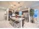 Bright kitchen features a center island with seating, stainless steel appliances, and dark wood cabinets at 10940 Oregano Ave, Las Vegas, NV 89166