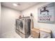 Laundry room featuring a modern washer and dryer set, storage, and a decorative sign at 10940 Oregano Ave, Las Vegas, NV 89166
