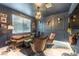 Dark blue office with seating and a workspace with a black desk and wall decorations at 10940 Oregano Ave, Las Vegas, NV 89166