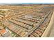 An aerial view shows a neighborhood with desert landscape, tile roofs, pools, and a stunning view of the mountains at 10972 Nicholas Jay Ave, Las Vegas, NV 89166