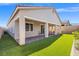 Exterior view of home showing a well-maintained yard with covered patio and artificial turf at 10972 Nicholas Jay Ave, Las Vegas, NV 89166