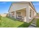 Exterior view of the home with a covered patio, artificial turf, and ample backyard space at 10972 Nicholas Jay Ave, Las Vegas, NV 89166