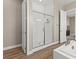 Bathroom featuring a walk-in shower with glass door, white tile, and wood-look flooring at 10972 Nicholas Jay Ave, Las Vegas, NV 89166