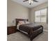 Comfortable bedroom features neutral walls, a ceiling fan, and a cozy bed with wood frame and side table at 10972 Nicholas Jay Ave, Las Vegas, NV 89166