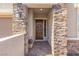 Inviting front entrance with stone accents, a dark-stained door, a decorative wreath, and brick pavers at 10972 Nicholas Jay Ave, Las Vegas, NV 89166