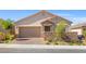Charming single-story home with a two-car garage, stone accents, desert landscaping, and a brick driveway at 10972 Nicholas Jay Ave, Las Vegas, NV 89166