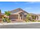 Charming single-story home featuring desert landscaping, stone accents, and a brick driveway on a sunny day at 10972 Nicholas Jay Ave, Las Vegas, NV 89166