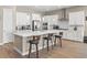 Modern kitchen with white cabinets, quartz countertops, stainless steel appliances, and wood-look tile flooring at 10972 Nicholas Jay Ave, Las Vegas, NV 89166