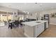 A bright kitchen featuring an open floor plan with wood floors and a kitchen island with bar seating at 10972 Nicholas Jay Ave, Las Vegas, NV 89166