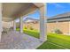 Spacious covered patio with brick pavers and view of the lush artificial grass yard at 10972 Nicholas Jay Ave, Las Vegas, NV 89166