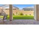 View of the backyard from the covered patio, featuring brick pavers and artificial grass at 10972 Nicholas Jay Ave, Las Vegas, NV 89166