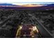 Aerial view of property showcasing a backyard pool and lush landscaping, set against the backdrop of city lights at 1144 Calico Ridge Dr, Henderson, NV 89011