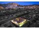 Aerial view showcases backyard oasis with a bright pool and lush landscaping against a picturesque mountain backdrop at 1144 Calico Ridge Dr, Henderson, NV 89011