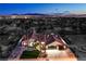 Stunning aerial view of single-Gathering home surrounded by desert landscape and city lights at 1144 Calico Ridge Dr, Henderson, NV 89011