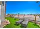 Backyard features artificial turf, two chaise lounges, and mature palms for a relaxing outdoor experience at 1144 Calico Ridge Dr, Henderson, NV 89011